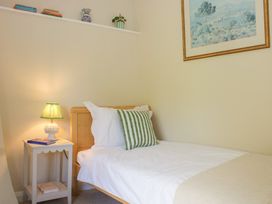 A bedroom with a bed and bedside table at Upper Frogpool Cottage in Crediton