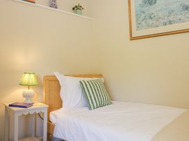 A bedroom with a bed and bedside table at Upper Frogpool Cottage in Crediton