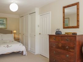 A bedroom with a bed and dresser at Upper Frogpool Cottage in Crediton