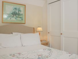 A bedroom with a bed and a lamp at Upper Frogpool Cottage in Crediton