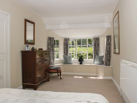 A bedroom with a dresser and window seat at Upper Frogpool Cottage in Crediton
