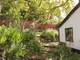 A garden with a pathway and flowers at Upper Frogpool Cottage in Crediton