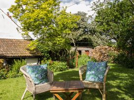 A garden with chairs and a table at Upper Frogpool Cottage in Crediton