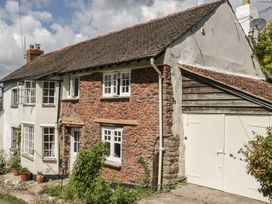 A cottage with stone walls and a garage at Upper Frogpool Cottage in Crediton