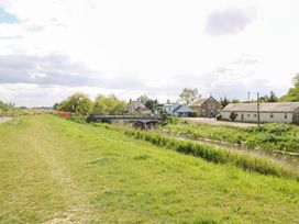 A view of a path alongside water with houses and trees at Hazel in 