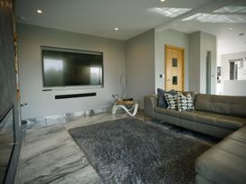 A living room with a television and sofa at Midways in Windermere