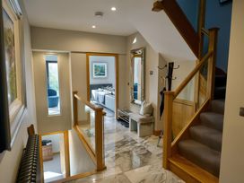 A hallway with a staircase and coat rack at Midways in Windermere