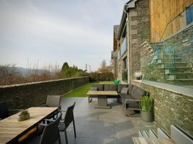 An outdoor patio with a sofa and table at Midways in Bowness-On-Windermere