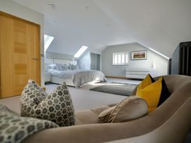 A bedroom with a bed, dresser, and cushions at Midways in Bowness-On-Windermere