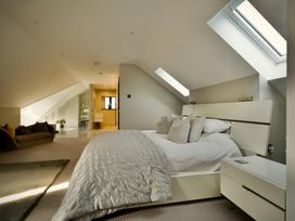 A bedroom with a bed and sofa at Midways in Bowness-On-Windermere