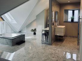 A bathroom with a bathtub and sink at Midways in Bowness-On-Windermere