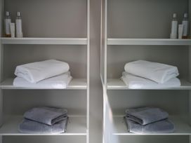 A bathroom shelf with towels and toiletries at Midways Bowness-On-Windermere