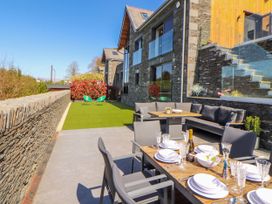 A patio with a dining set and green chairs at Midways in Bowness-On-Windermere