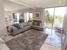 A living room with a sofa and large windows at Midways in Bowness-On-Windermere