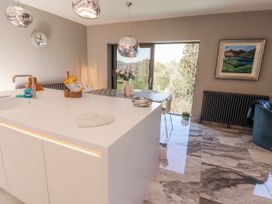 A kitchen with a countertop sink and a dining table at Midways in Bowness-On-Windermere