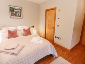 A bedroom with a bed and door at Midways Bowness-On-Windermere