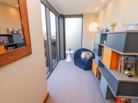 A snug with a blue chair and bookshelf at Midways in Bowness-On-Windermere