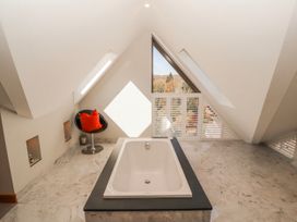 A bathroom with a bathtub and window at Midways in Bowness-On-Windermere
