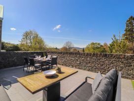 An outdoor patio with a dining table and chairs at Midways in Bowness-On-Windermere