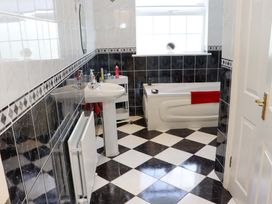 A bathroom with a bath tub and sink at BREAGHMORE