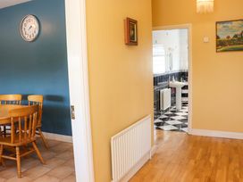 A dining room with table and chairs leading to a bathroom at BREAGHMORE