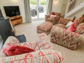 A living room with sofas and a television at Barley Cottage in Oxwich
