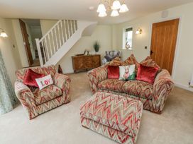 A living room with an armchair and sofa at Barley Cottage, Oxwich