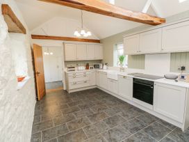A kitchen with cabinets and appliances at Barley Cottage in Oxwich