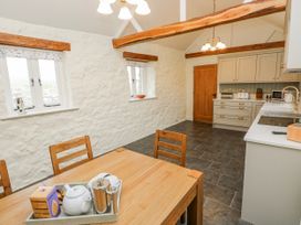 A kitchen with a table and chairs at Barley Cottage Oxwich
