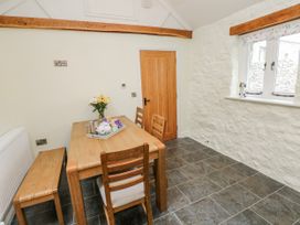 A dining room with a table and chairs at Barley Cottage in Oxwich