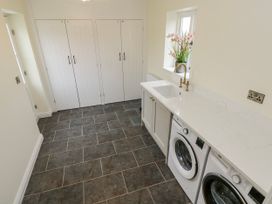 A laundry room with washing machine and dryer at Barley Cottage Oxwich