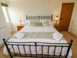 A bedroom with a bed and nightstands at Barley Cottage in Oxwich