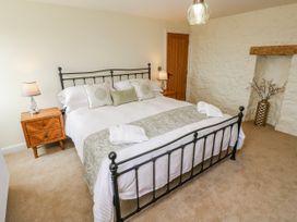 A bedroom with a bed and nightstand at Barley Cottage in Oxwich