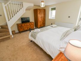 A bedroom with a bed and furniture at Barley Cottage in Oxwich