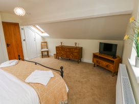 A bedroom with a bed and furniture at Barley Cottage in Oxwich