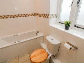 A bathroom with a bath tub and toilet at Barley Cottage in Oxwich