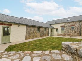 An outdoor area with stone walls and grass at Barley Cottage in Oxwich