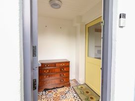 An entryway with a chest of drawers and a yellow door at Turraheen in Cashel
