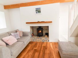 A living room with a sofa and a wood stove at Turraheen in Cashel