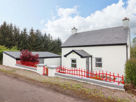 A cottage with a red fence and driveway at Artist’s Cottage, Cashel, County Tipperary