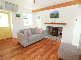 A living room with a sofa and fireplace at Artist’s Cottage, Cashel, County Tipperary