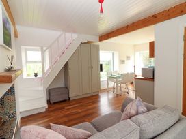 A living room with a staircase and dining area at Artist’s Cottage Cashel, County Tipperary