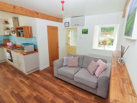 A living room with kitchen appliances at Artist’s Cottage in Cashel, County Tipperary