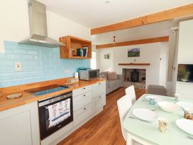 A kitchen with appliances and dining area at Artist’s Cottage in Cashel, County Tipperary