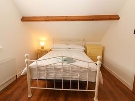 A bedroom with a bed and a yellow dresser at Artist’s Cottage, Cashel, County Tipperary