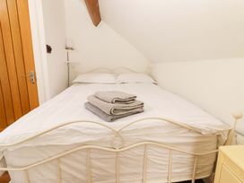 A bedroom with a bed and towels folded on top at Artist’s Cottage in Cashel, County Tipperary