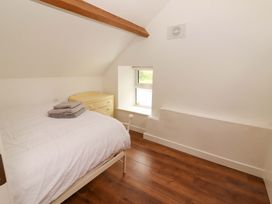 A bedroom with a bed and dresser at Artist’s Cottage in Cashel, County Tipperary