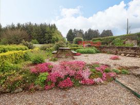 A garden with flowers and a seating area at Artist’s Cottage in Cashel, County Tipperary