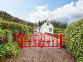 An entrance with a red gate leading to a house at Artist’s Cottage in Cashel, County Tipperary