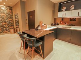 A kitchen with an island and bar stools at Bounty Boutique on the Lakes in Bowness-On-Windermere